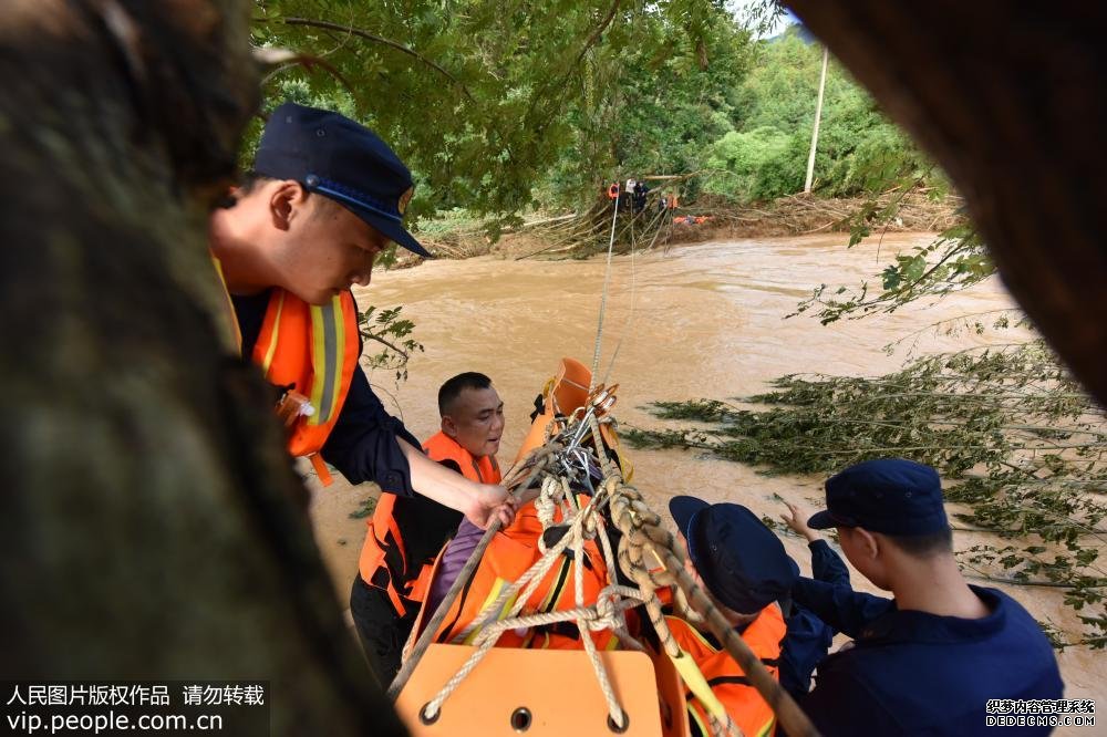 6月13日，消防救援大队正在从河对面救援被洪水围困的双目失明的老人。