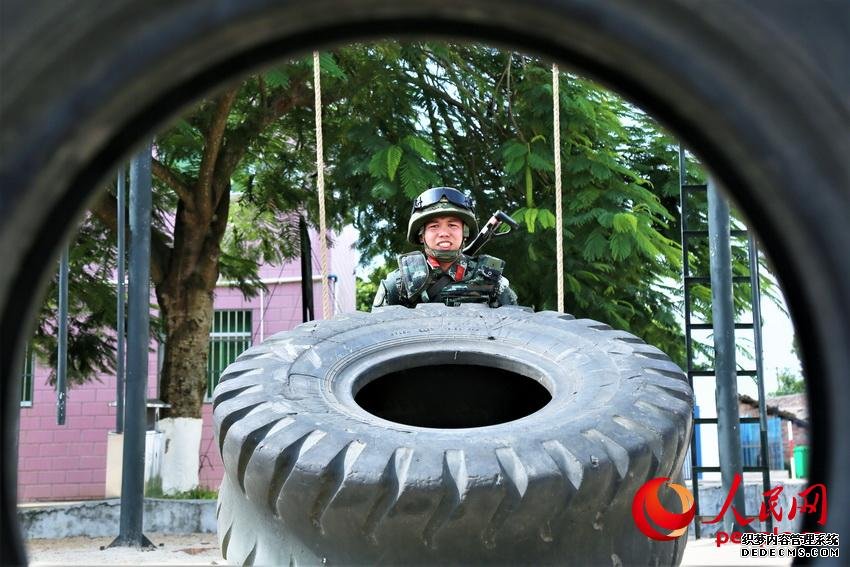 一名武警官兵在进行翻动重卡外轮胎训练，重达300多斤的轮胎每次一翻动都需要拼尽全力。